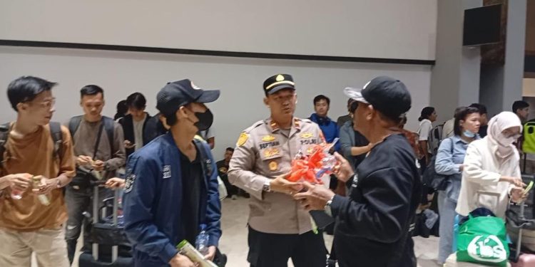 Polri Sambut Penumpang dan Bagikan Snack di Bandara Soekarno-Hatta